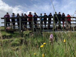 Happy hikers standing on a wooden bridge among nature on a Green Therapy Healthy Hike with Positive Steps Outdoors.