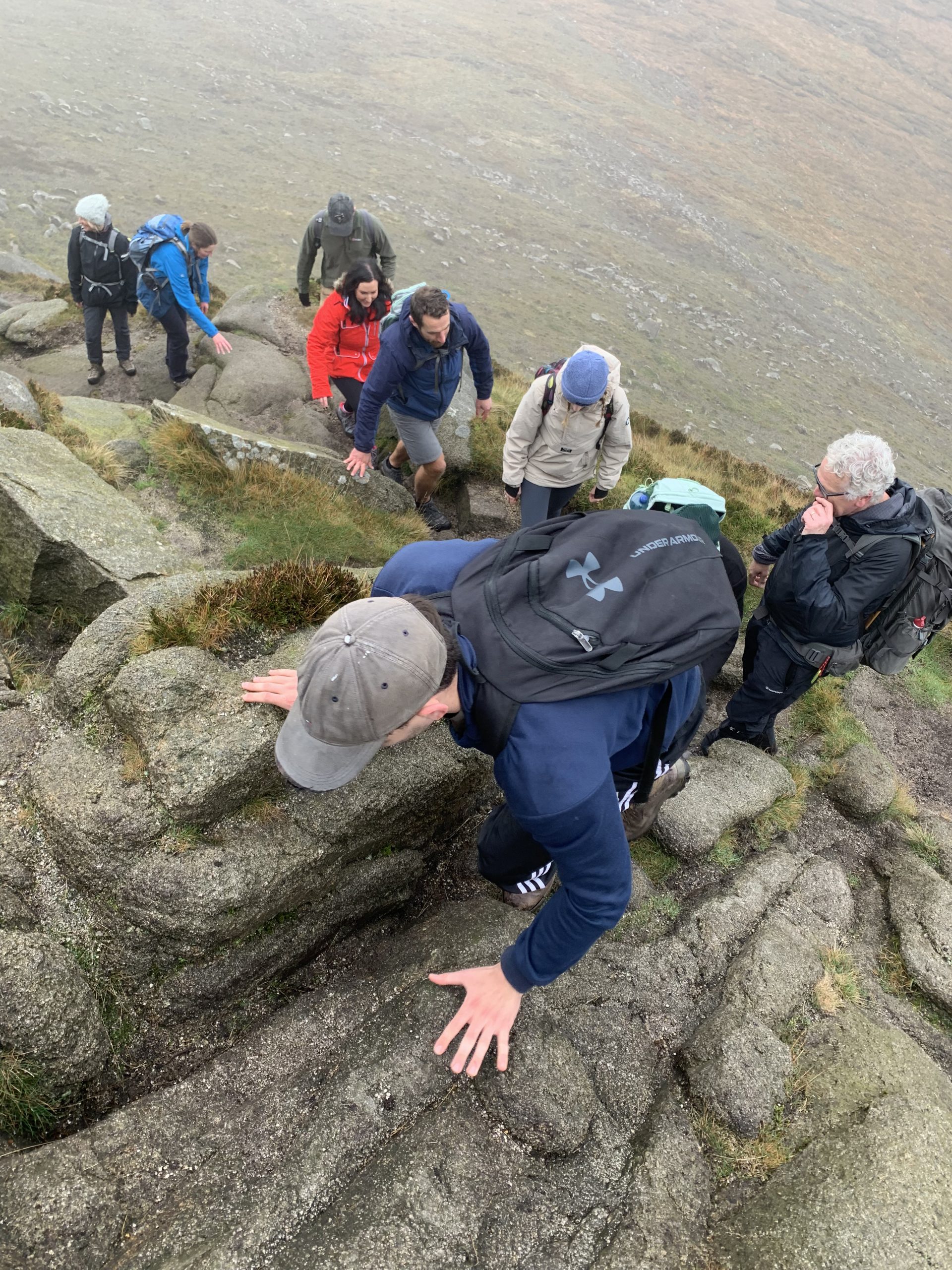 Overhead view of a group of walkers scrambing to the summit of Slieve Doan
